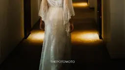 Ochi Rosdiana mengenakan bridal robe ini sebelum memakai baju adat Minang Koto Gadang. Ini potret tampak belakang Ochi Rosdiana mengenakan bridal robe. Sahabat Audi Marissa ini memilih bridal robe yang simpel namun elegan dengan memperlihatkan punggung indahnya. Model lengan bridal robe-nya yang lebar membuat bridal robe ini jadi semakin cantik. (Liputan6.com/IG/@ochi24)