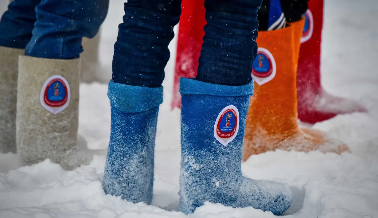 Para pemain mengenakan sepatu tradisional Rusia, Valenki, saat pertandingan persahabatan antara wartawan dan mahasiswa asing di lapangan bersalju di Nizhny Novgorod, Rusia, Minggu (21/1). (AFP PHOTO/Mladen ANTONOV)