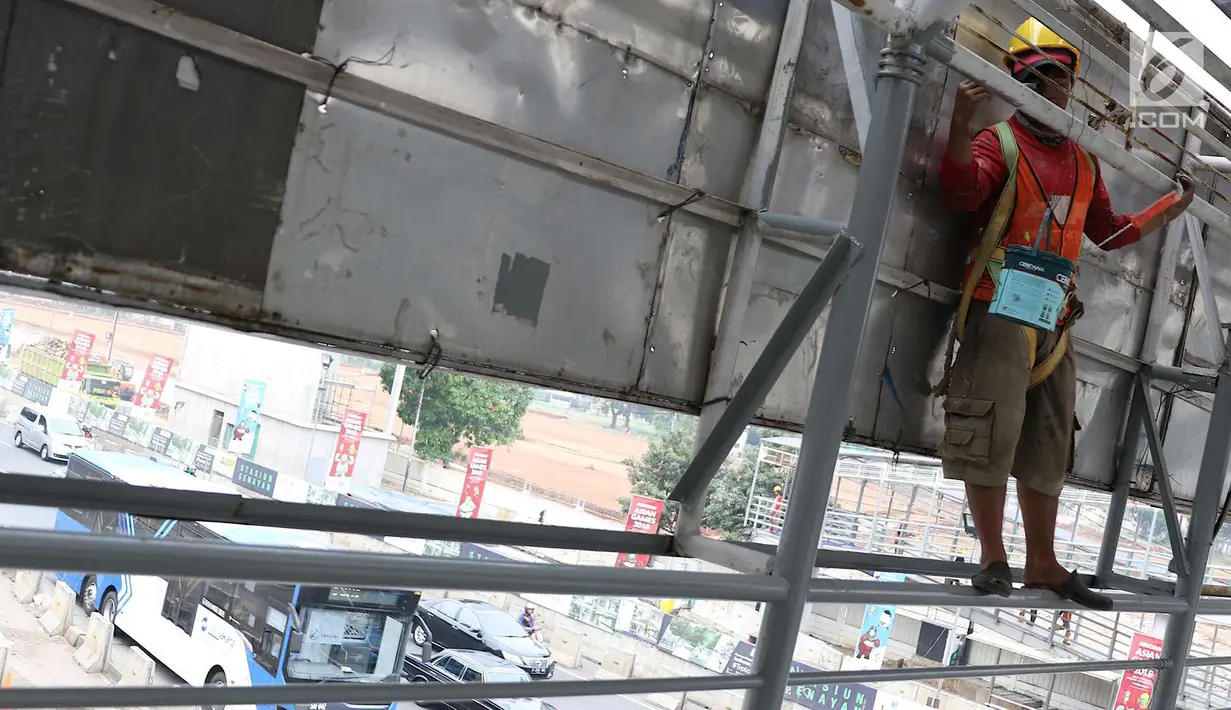 Pekerja mengecat jembatan penyeberangan orang di kawasan Senayan, Jakarta, Jumat (6/7). Pengecatan tersebut merupakan bagian dari proyek revitalisasi JPO guna meningkatnya kenyamanan pejalan kaki. (Liputan6.com/Immanuel Antonius)
