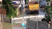 Kondisi banjir di Perumahan Nerada Estate Ciputat akibat jebolnya tanggul karena tertimpa tanah longsor, di Tangerang Selatan, Banten, Sabtu (12/6/2021). Longsor yang menimpa sejumlah rumah membuat tanggul pembatas kali jebol dan air meluap sehingga menyebabkan banjir. (Liputan6.com/Angga Yuniar)