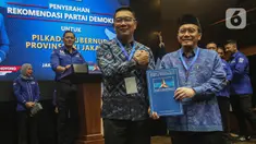 Bakal Calon Gubernur dan Bakal Calon Wakil Gubernur, Ridwan Kamil (tengah) bersama Suswono berpose usai menerima surat rekomendasi Partai Demokrat untuk maju pada Pilkada Provinsi DKI Jakarta di kantor Dewan Pimpinan Pusat (DPP) Partai Demokrat, Jakarta, Selasa (27/8/2024). (Liputan6.com/Angga Yuniar)