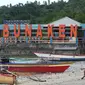 Warga duduk di pinggir pantai dekat tulisan 'Welcome to Bunaken' di Pulau Bunaken, Manado, Sabtu (17/12). Pemprov Sulut gencar melakukan promosi pariwisata dengan tujuan mendatangkan turis sebanyak mungkin hingga ke Tiongkok. (Liputan6.com/Fery Pradolo)