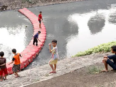 Anak-anak bermain di sungai buatan di kawasan Kuningan, Jakarta, Senin (13/8). Belum tersedianya ruang terbuka hijau yang cukup di Ibukota menyebabkan anak-anak tersebut bermain di tempat yang tidak semestinya. (Liputan6.com/Immanuel Antonius )