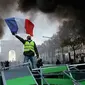 Demonstran mengibarkan bendera Prancis saat kerusuhan menentang kenaikan harga bahan bakar di Paris, Prancis, Sabtu (24/11). Demonstrasi terjadi oleh dorongan gerakan "rompi kuning". (AP Photo/Michel Euler)