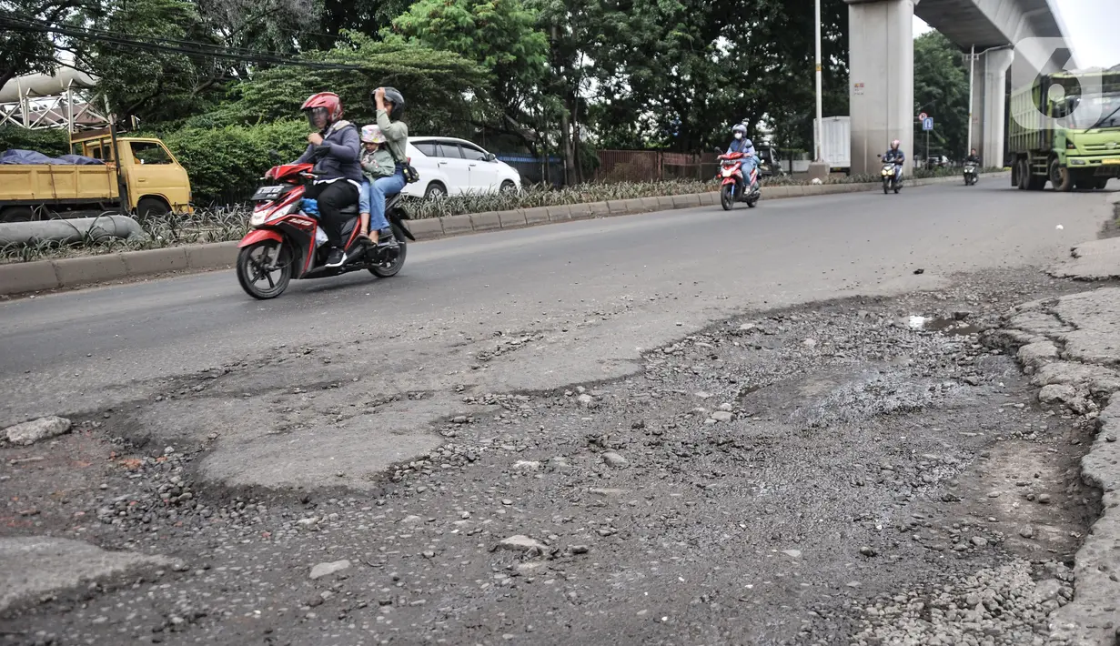 Pengendara sepeda motor melintasi Jalan Raya Bekasi,  yang rusak dan berlubang di Cakung, Jakarta Timur, Selasa (14/3/2023). Minimnya perawatan menyebabkan kondisi Jalan Raya Bekasi arah Cakung ke Pulogebang rusak dan berlubang yang dapat membahayakan keselamatan pengendara, terlebih saat musim penghujan. (merdeka.com/Iqbal S Nugroho)