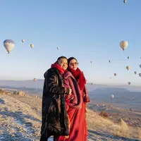 Reuni dengan keluarga besar Atta Halilintar, Ashanty tampil begitu mempesona dengan jaket tebal, rok panjang warna merah saat berada di Cappadocia. (Instagram/ashanty_ash).
