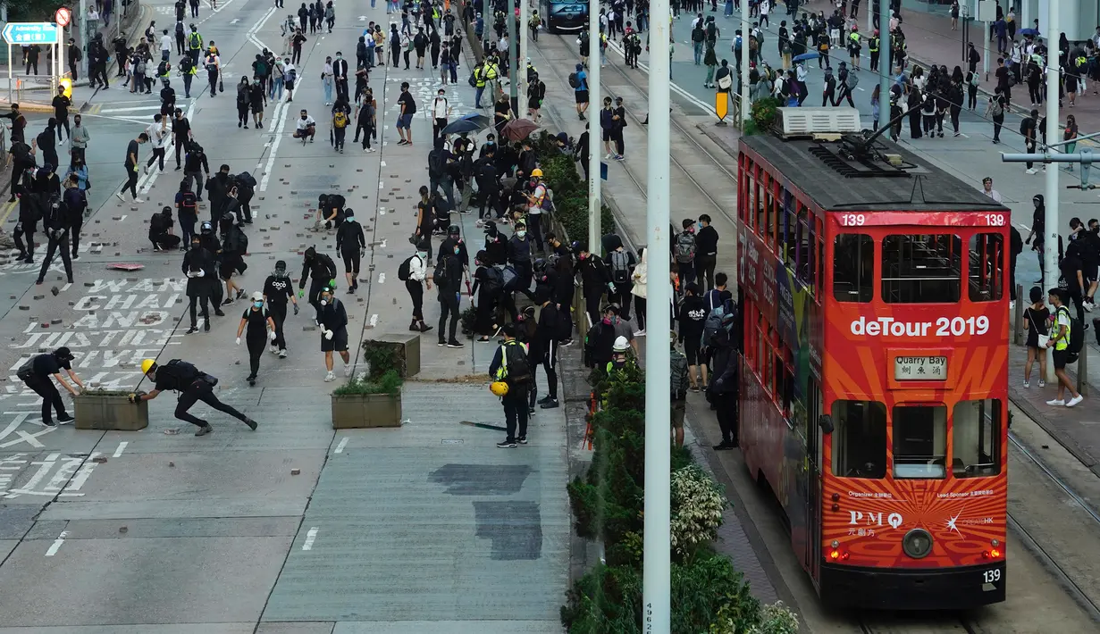 Demonstran memblokade jalan raya dengan batu bata, Hong Kong, Senin (11/11/2019). Ketegangan di Hong Kong semakin meningkat setelah polisi menembak seorang demonstran hingga kritis. (AP Photo/Vincent Yu)