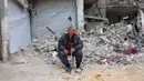 Mohammed Kanoua, 80 tahun, berpose di depan rumahnya yang hancur di Jabalia, Jalur Gaza utara, pada 9 Februari 2025. (Bashar TALEB/AFP)