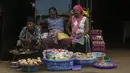 Perempuan menjual bawang dan kentang di pasar Kaporo di Conakry, Guinea, Senin (13/9/2021). Pasukan elit militer Guinea melakukan kudeta dan menangkap Presiden Alpha Conde pada Minggu, 5 September lalu. (AP Photo/ Sunday Alamba)