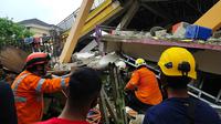 Tim penyelamat mencari korban yang terperangkap dalam sebuah bangunan runtuh di Mamuju, Sulawesi Barat, Indonesia, Jumat (15/1/2021). BMKG menyebut pusat gempa berada di darat, 6 kilometer timur laut Majene pada kedalaman 10 kilometer. (HANDOUT/NATIONAL SEARCH AND RESCUE AGENCY/AFP)