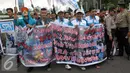 Buruh membawa spanduk saat menggelar aksi May Day di depan gedung DPR, Jakarta, Minggu (1/5). Buruh membawa 12 tuntutan diantaranya menuntut dihapuskannya Sistem Kerja Kontrak dan Outsorcing. (Liputan6.com/Helmi Afandi)