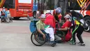 Salah satu volunteer Asian Para Games 2018 membantu menaikkan pengunjung ke kendaraan khusus difabel di dekat pintu utama GBK, Jakarta, Kamis (11/10). Mereka bertugas membantu kelancaran Asian Para Games 2018. (Liputan6.com/Helmi Fithriansyah)