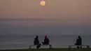 <p>Orang-orang mengambil gambar Super Moon terbit di atas Lisbon, Portugal, Kamis (11/8/2022). Bulan Purnama Agustus 2022 akan menjadi fenomena Supermoon terakhir tahun ini. Bulan Purnama Agustus dijuluki "Sturgeon Moon". (AP Photo/Armando Franca)</p>