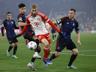 Gelandang Bayern Munchen #27 Konrad Laimer (tengah) bersaing memperebutkan bola dengan pemain FC Copenhagen pada laga matchday kelima Grup A Liga Champions di Allianz Arena, Kamis (30/12) dini hari WIB. (MICHAELA REHLE / AFP)