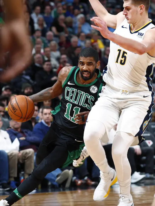 Pemain Boston Celtics, Kyrie Irving (kiri) berusaha melewati adangan pemain Denver Nuggets, Nikola Jokic pada laga NBA basketball game di Pepsi Center, Denver, (29/1/2018). Celtics menang 111-110. (AP/David Zalubowski)