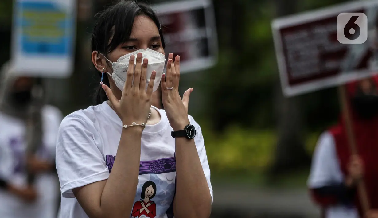 Aktivis yang tergabung dalam Serikat Buruh Migran Indonesia (SBMI) melakukan aksi damai di Kawasan Monas, Jakarta Pusat, Minggu (13/3/2022). Mereka meminta agar pekerja perempuan diberikan hak yang sama seperti pekerja laki-laki dan tidak ada lagi tindakan diskriminasi. (Liputan6.com/Johan Tallo)
