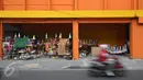 Pengendara motor melintas di depan pedagang terompet di kawasan Kota Tua, Jakarta. Selasa (27/12). Terompet tersebut dijual dengan harga bervariasi, mulai dari Rp3ribu hingga Rp15ribu, tergantung bentuk dan ukurannya. (Liputan6.com/Immanuel Antonius)