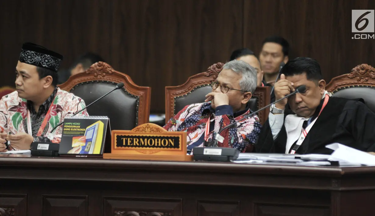 Ekspresi Ketua Umum KPU Arief Budiman (tengah) saat mengikuti sidang perdana sengketa Pemilu Legislatif 2019 di Gedung Mahkamah Konstitusi (MK), Jakarta, Selasa (9/7/2019). Sidang putusan Pileg 2019 akan digelar pada 6-9 Agustus 2019. (merdeka.com/Iqbal Nugroho)