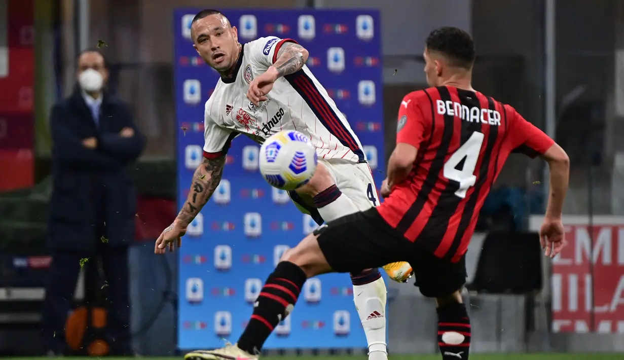 Gelandang Cagliari, Radja Nainggolan (kiri) berebut bola dengan gelandang AC Milan, Ismael Bennacer pada pekan ke-37 Serie A di San Siro, Senin (17/5/2021) dini hari WIB.  AC Milan gagal menjauh di klasemen Liga Italia usai imbang 0-0 lawan Cagliari. (MIGUEL MEDINA / AFP)