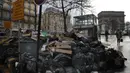 Orang-orang berjalan melewati tumpukan kantong sampah di Paris (4/2/2020). Sampah menumpuk di jalan-jalan Paris dan Marseille karena pemogokan perubahan pada sistem pensiun nasional Prancis.  (AP Photo/Christophe Ena)