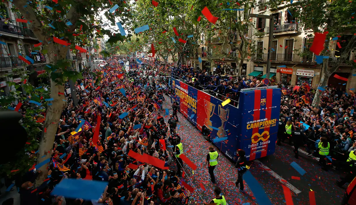 Para warga dan penggemar menyambut pemain Barcelona saat parede di Barcelona (30/4). Barcelona langsung mengelar parade perayaan gelar juara sehari setelah mengalahkan Deportivo La Coruna di pertandingan ke-35 Liga Spanyol. (AP/Manu Fernandez)