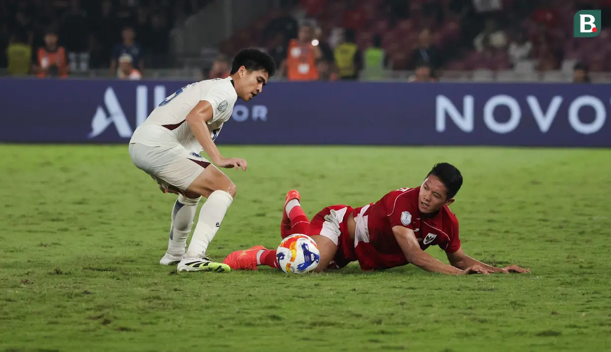 Bek Timnas Indonesia U-23, Alfharezzi Buffon jatuh bangun mempertahankan bola dari gelandang Timnas Thailand U-23, Seksan Ratree dalam laga semifinal Piala AFF U-23 2025 di Stadion Utama Gelora Bung Karno, Jakarta, Jumat (25/7/2025). (Bola.com/Abdul Aziz).
