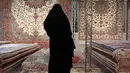 Pengunjung melihat-lihat karpet tenun yang dipamerkan dalam pameran di Teheran, Iran, Kamis (29/8/2019). AS menghentikan impor karpet Iran setelah Presiden Donald Trump menjatuhkan sanksi terkait program nuklir negara tersebut. (AP Photo/Vahid Salemi)