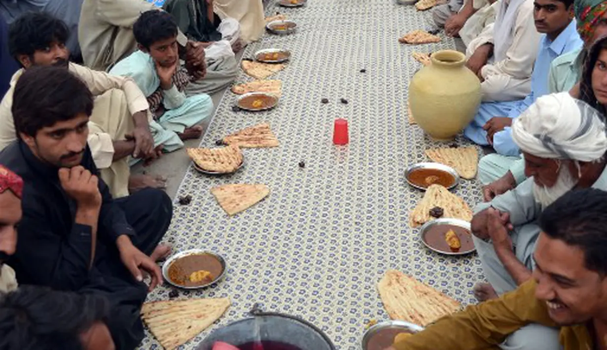 Para peserta buka puasa bersama ini mengaku selain bisa mendapatkan makanan berbuka secara gratis mereka juga bisa menjalin kebersamaan, Pakistan, Quetta, Rabu (2/7/2014) (AFP PHOTO/BANARAS KHAN)