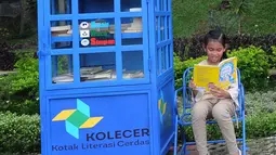 Seorang anak membaca buku yang ada di layanan Kotak Literasi Cerdas (Kolecer) di Taman Sempur, Bogor, Jawa Barat, Kamis (20/12). Selain menumbuhkan budaya literasi, Kolecer juga diharap mampu meningkatkan minat baca masyarakat. (Merdeka.com/Arie Basuki)