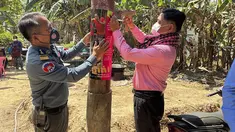 Dalam foto yang dirilis oleh Kementerian Kesehatan Kamboja ini, seorang petugas kesehatan hewan Kamboja, kanan, dan seorang perwira polisi militer memasang poster tentang kesadaran akan ancaman virus H5N1 dengan harapan dapat mengedukasi penduduk desa untuk menjaga kesehatan mereka, di Prey Veng, Kamis (23/2/2023). Seorang anak perempuan berusia 11 tahun di Kamboja meninggal karena flu burung dalam infeksi H5N1 manusia pertama yang diketahui di negara itu sejak 2014, kata pejabat kesehatan. (Cambodia Ministry of Health via AP)