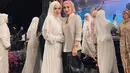 Penyanyi Lucky Resha juga hadir di acara pernikahan anak Elma. Ia tampil menawan kenakan maxi dress dan hijab syar’i serba putihnya. [@imelpc].