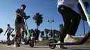 Pengendara menaiki skuter listrik dari startup LimeBike di sepanjang Venice Beach, Los Angeles, 13 Agustus 2018. Kota besar masih berjuang mengurangi kendaraan pribadi di jalan, tapi tidak pernah mendapatkan solusi tepat. (Mario Tama/Getty Images/AFP)