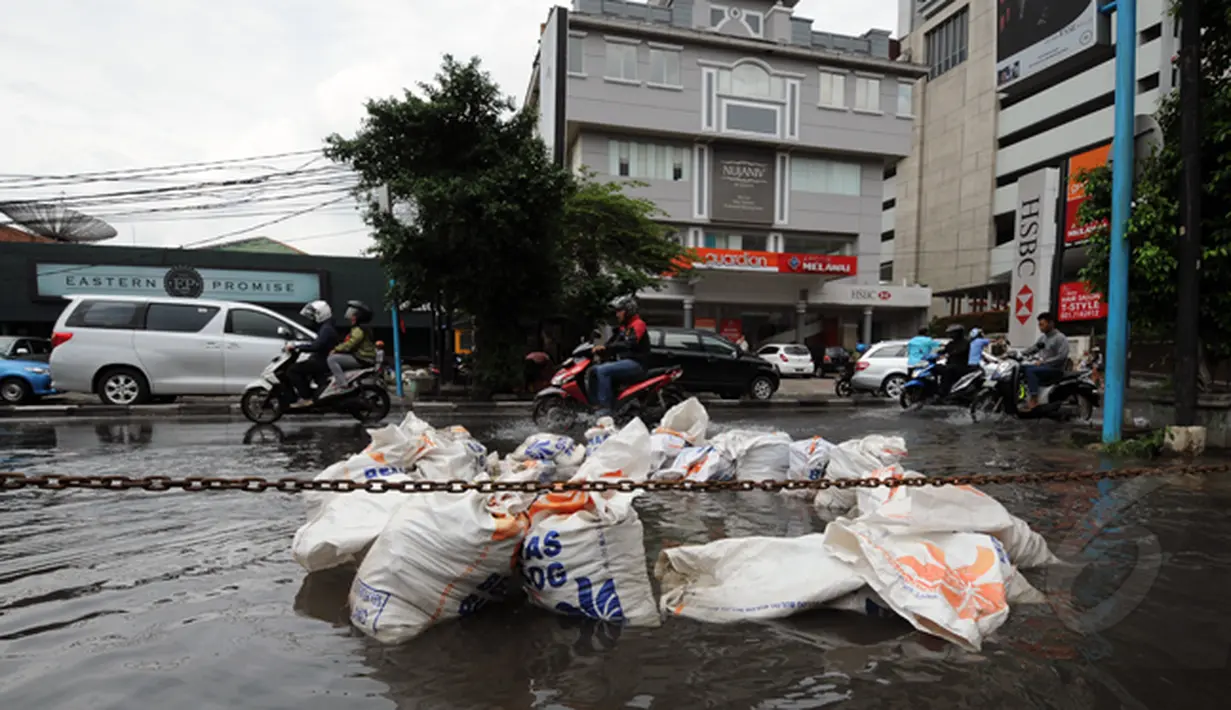 Hujan yang mengguyur Jakarta sejak Minggu (8/2/2015) mengakibatkan banjir di sejumlah wilayah. Tumpukan karung pasir diletakkan di sisi jalan Kemang Raya, Jakarta, Selasa (10/2/2015). (Liputan6.com/Helmi Fithriansyah)