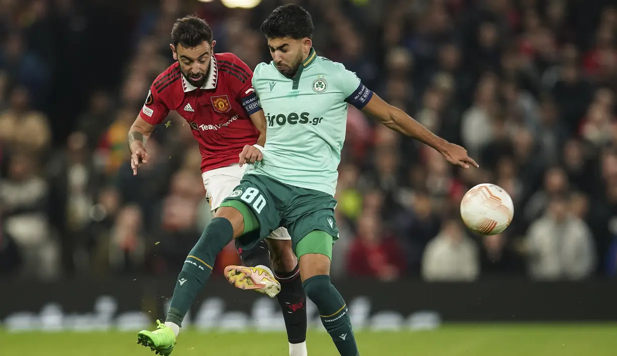 Gelandang Manchester United atau MU, Bruno Fernandes berebut bola dengan penyerang Omonia Nicosia, Andronikos Kakoullis dalam laga matchday 4 fase grup Liga Europa 2022/2023 di Old Trafford, Jumat dini hari WIB (14/10/2022). Meski sukses meraih tiga poin, MU masih tertahan di peringkat dua klasemen Grup E dengan poin 9. (AP Photo/Dave Thompson)