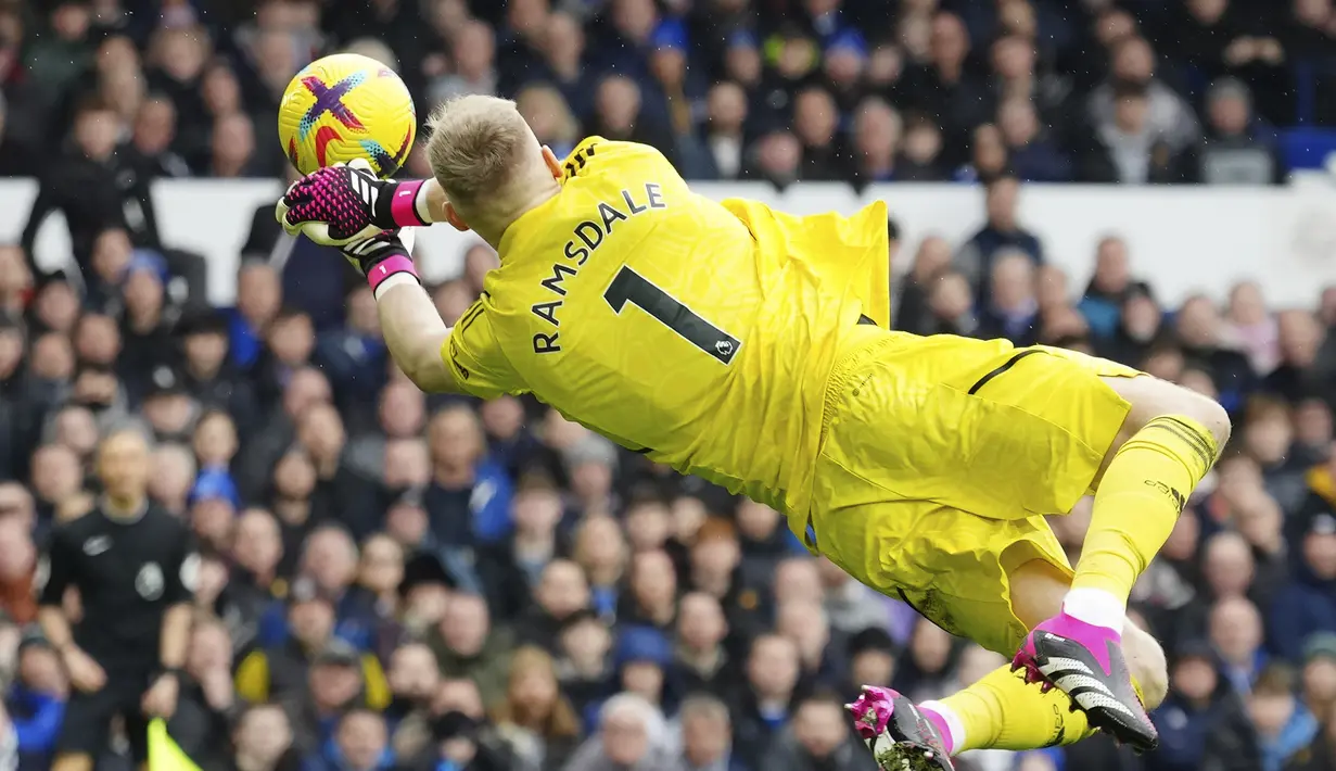 Kiper Arsenal, Aaron Ramsdale terbang untuk menepis bola dari ancaman pemain Everton dalam laga pekan ke-22 Liga Inggris 2022/2023 di Goodison Park, Liverpool, Sabtu (4/2/2023) malam WIB. (AP Photo/Jon Super)