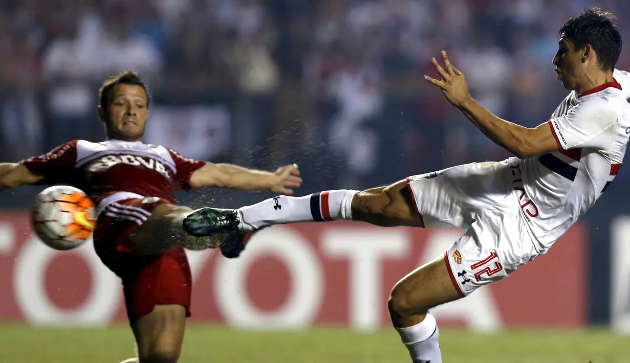 Pemain Sao Paulo Jonathan Calleri (kanan) saat melakukan tendangan bola yang dihadang oleh pemain River Plate Nicolas Domingo di Stadion Morumbi , Sao Paulo , Brasil, (13/4/2016) . REUTERS / Paulo Whitaker