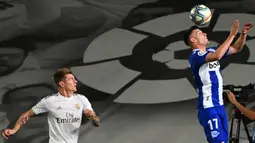 Gelandang Real Madrid, Toni Kroos (kiri) berusaha merebut bola dari bek Alaves, Adrian Marin Gomez pada lanjutan Liga Spanyol di stadion Alfredo di Stefano, Sabtu (11/7/2020). Real Madrid menang 2-0 lewat gol Karim Benzema dan Marco Asensio. (GABRIEL BOUYS/AFP)