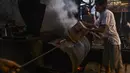 Pekerja memanggang biji kopi robusta dengan cara tradisional di sebuah produsen biji kopi kecil di Banda Aceh (14/11/2020). (AFP/Chaideer Mahyuddin)