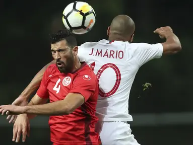 Duel pemain Tunisia, Yassine Meriah (kiei) dan pemain Portugal, Joao Mario pada laga uji coba di Estadio Municipal de Braga, (28/5/2018) waktu setempat. Portugal dan Tunisia bermain imbang 2-2. (AP/Luis Vieira)