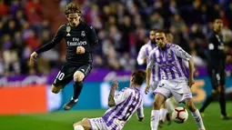 Gelandang Real Madrid, Luka Modric berusaha melewati pemain Real Valladolid, Luismi Sanchez selama pertandingan lanjutan La Liga Spanyol di stadion Jose Zorrilla,Valladolid (10/3). Madrid menang telak 4-1 atas Valladolid. (AP Photo/Alvaro Barrientos)