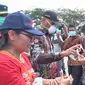 Wali Kota Jayapura, Benhur Tomi Mano dan Kadis Kesehatan Kota Jayapura, membagikan masker dan hand sanitizer kepada sopir di Terminal Entrop Jayapura. (Liputan6.com/Katharina Janur/Humas Pemkot Jayapura)