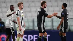 Pemain Olympique Lyon, Kenny Tete dan Joachim Andersen, merayakan kemenangan agregat dari Juventus pada laga leg kedua Liga Champions 2019/2020 di Stadion Allianz, Sabtu (8/8/2020) dini hari WIB. Juventus kalah agregat 2-2 atas Olympique Lyon. (AFP/Miguel Medina)