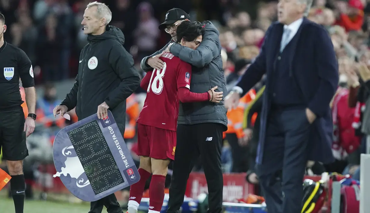 Pelatih Liverpool, Jurgen Klopp memeluk gelandang Takumi Minamino usai ditarik keluar pada pertandingan melawan Everton di babak ketiga Piala FA di Anfield, Minggu (5/1/2020). Minamino bermain selama 70 menit, lalu digantikan Alex Oxlade-Chamberlain. (AP Photo/Jon Super)