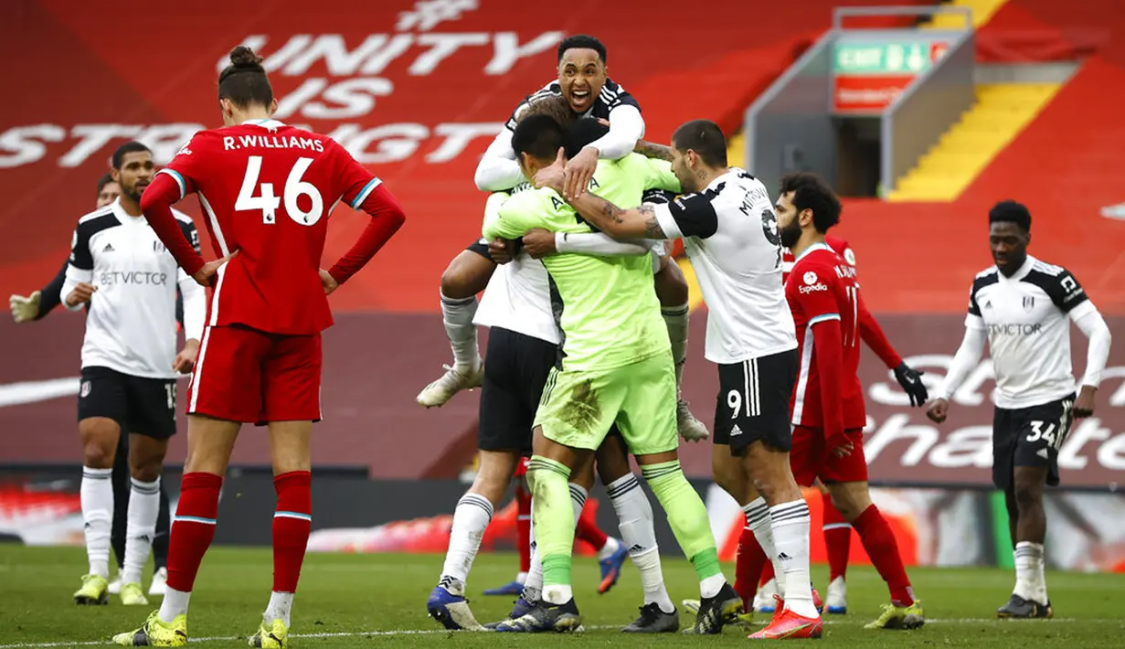 Para pemain Fulham merayakan kemenangan atas Liverpool pada akhir pertandingan Liga Inggris di Stadion Anfield, Liverpool, Inggris, Minggu (7/3/2021). Liverpool takluk 0-1 dari Fulham. (Phil Noble/Pool via AP)