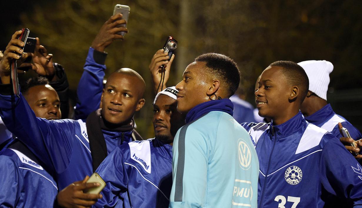 Pemain MU, Anthony Martial diserbu fans untuk diajak selfie usai latihan jelang laga menghadapi Jerman di Yvelines, Jerman, Selasa (10/11/2015). (AFP Photo/Franck Fife)
