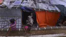 Anak-anak Rohingya bermain di depan rumah darurat di Kamp Pengungsi Kutupalong di Cox's Bazar, Bangladesh, Senin (22/7/2019). Lebih dari satu juta etnis Rohingya melarikan diri dari Myanmar dan menetap di Kutupalong yang merupakan salah satu kamp pengungsi terbesar di dunia. (MUNIR UZ ZAMAN/AFP)