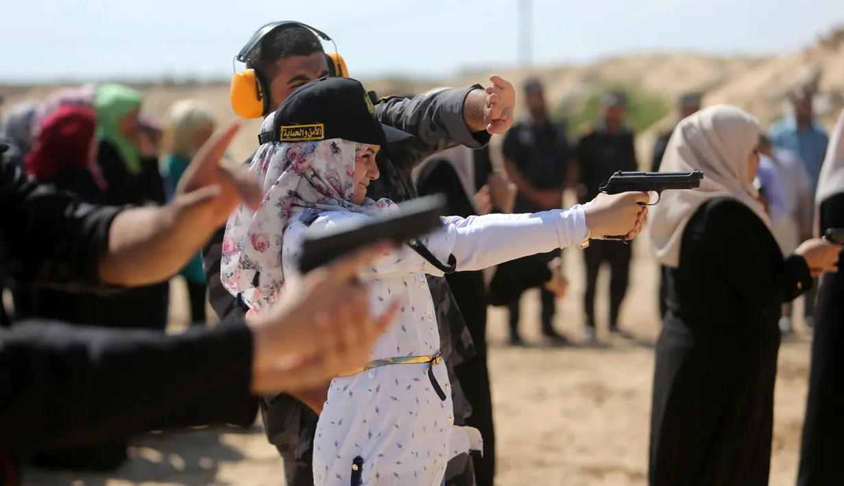Seorang wanita Palestina berlatih menembak di Khan Younis di Jalur Gaza, Minggu (24/7). Pelatihan menembak tersebut dilatih langsung oleh anggota Perlindungan dan Keamanan Hamas. (REUTERS/ Ibraheem Abu Mustafa)