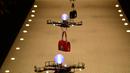 Barisan pesawat tanpa awak (drone) membawa koleksi tas tangan Dolce & Gabbana pada Milan Fashion Week 2018, Minggu (25/). Bak model, deretan drone terbang berbaris rapi diiringi soundtrack 'Black Panther', 'All of the Stars'. (AP/Antonio Calanni)