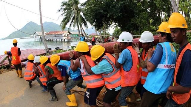 Minimnya infrastruktur membuat karyawan PLN harus memikul tiang-tiang listrik seberat ratusan kilogram (kg) untuk bisa menerangi wilayah di Natuna, (Liputan6.com/Nurseffi Dwi Wahyuni)