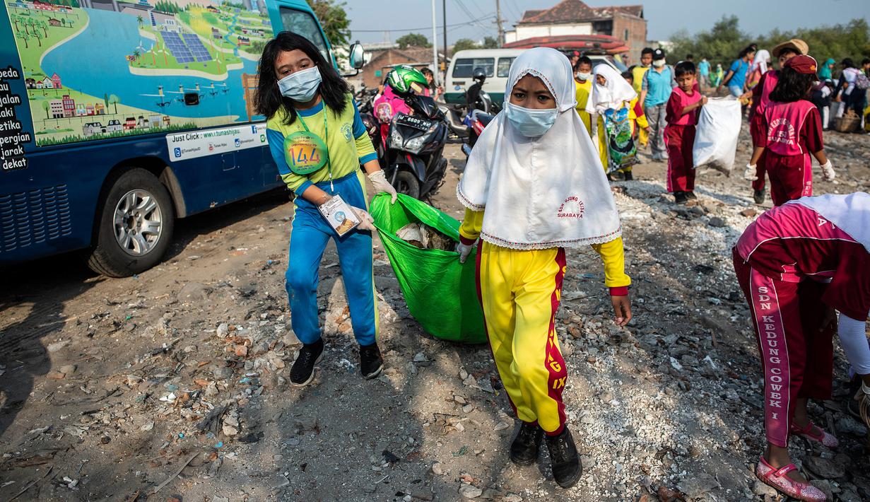 Anak-anak mengikuti aksi bersih sampah pada rangkaian kegiatan World Cleanup Day di kawasan pantai di Surabaya, Jawa Timur, Sabtu (21/9/2019). World Cleanup Day adalah sebuah gerakan bersih-bersih sampah terbesar di dunia yang dilaksanakan secara serentak di 157 negara.  (JUNI KRISWANTO / AFP)